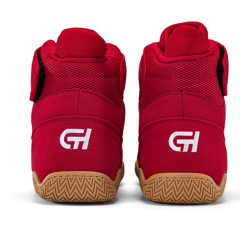 A pair of red high-top athletic CH Gear XXVI Bloodline Wrestling Shoe shown from the back, featuring a white stylized 'GH' logo on the heel and a brown zigzag-patterned rubber sole, set against a plain white background.