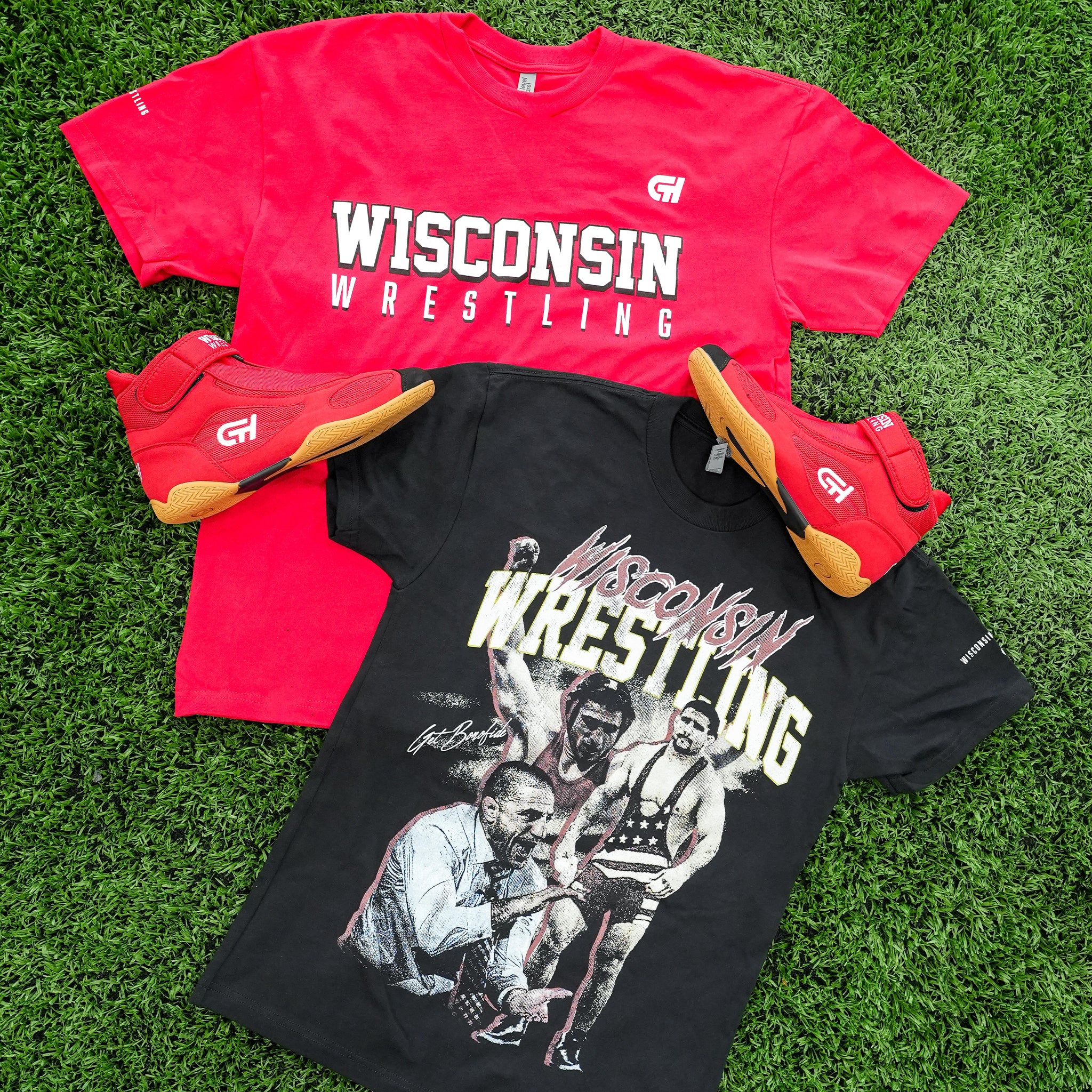 Red and black CH Gear Wisconsin Wrestling t-shirts displayed on green turf alongside a pair of red CH Gear high-top wrestling shoes with gum soles