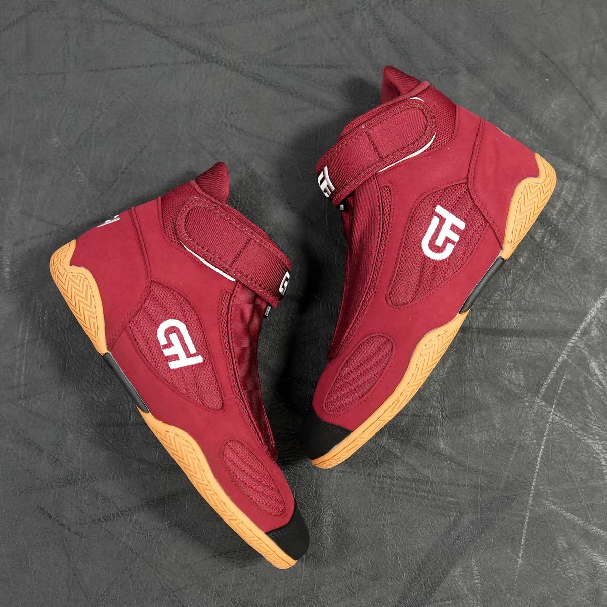 A pair of red high-top CH Gear XXVI Heritage Shoes with white logo graphics and tan outsole sections, displayed on a dark gray textured surface.